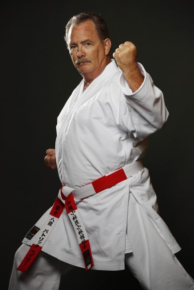 Portrait of Pat Haley in a white karate uniform and red and white belt